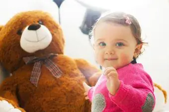 Petite fille en bas âge jouant avec un gros ours en peluche