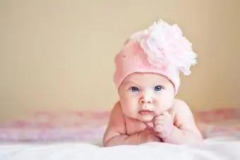 Model dítěte v klobouku s květinou