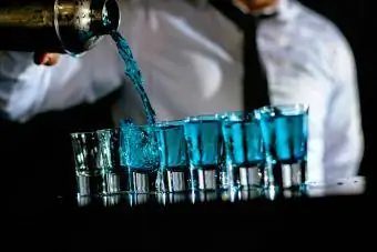 Barkeeper bereitet blaue Cocktail-Shots zu