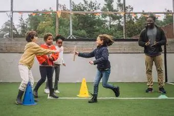 Nauczyciel motywuje uczniów do uprawiania sportu na placu zabaw