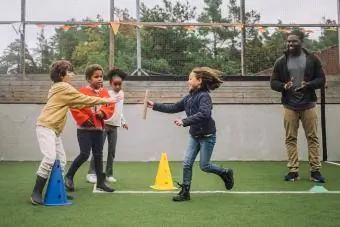 Müəllim şagirdləri oyun meydançasında idmanla məşğul olmağa həvəsləndirir