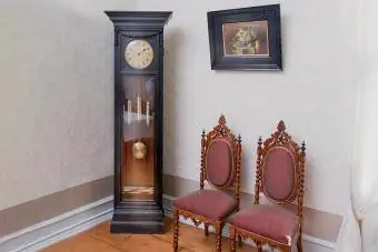 Vectēva pulkstenis un divi krēsli viesnīcas istabā