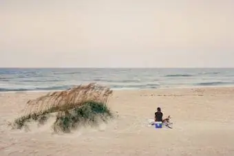 vrouw zittend op het strand van Ocracoke Island