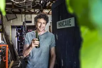 Homme buvant de la bière dans sa caverne d'hommes