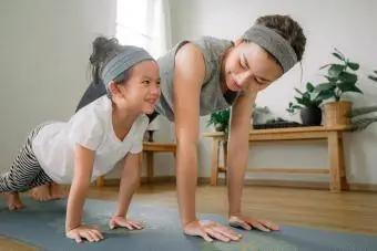 Mãe e filha fazendo ioga em casa