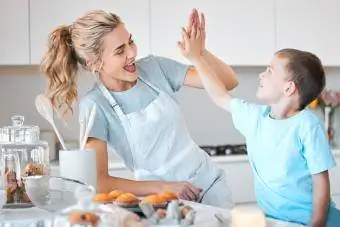 Masayang ina na nag-high five sa kanyang anak sa kusina