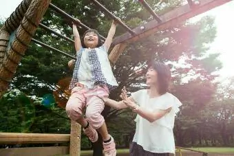 Mor och dotter leker i parken