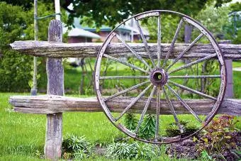 Ukrasni starinski drveni kotač visi na ogradi