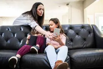 mamma sätter föräldrakontroll på barns telefon och surfplatta