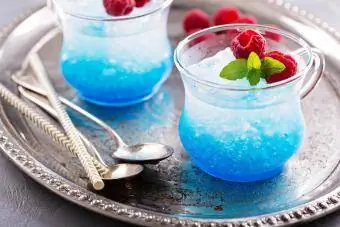 Modrý malinový koktejl s mátou v malých skleněných pohárcích