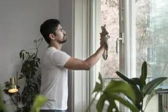 njeri që pastron një dritare