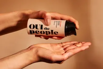 Foto dua tangan menggunakan OUI the People's Cheat Sheet yang menurap semula serum badan.
