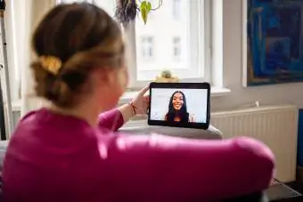 Vrouw thuis videobellen met een vriend