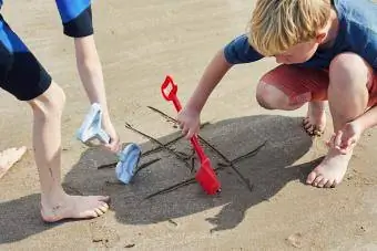 niños jugando tres en raya en la playa