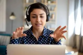 Nakasuot ng wireless headset na video calling ang babae sa laptop