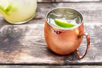 Eski ahşap bir masanın üzerinde bakır bir kupanın içinde Kentucky Mule