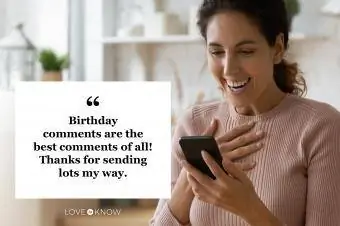 laiminga moteris, skaitanti gimtadienio komentarus savo telefone iš socialinės žiniasklaidos