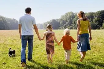 obitelj koja zajedno šeta vani držeći se za ruke