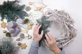 Cov poj niam laus decorating lub christmas wreath