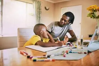 Evde oğlunun ödevlerine yardım eden baba