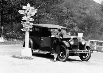 CIRCA 1920: Femeie sprijinită pe mașină