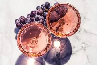 Երկու բյուրեղյա ցողունով բաժակ վարդագույն գինիով