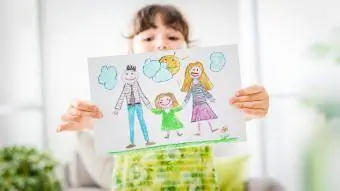 Meitene, kam rokās viņas ģimenes zīmējums