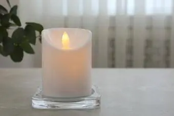 Hehkuva koristeellinen LED-kynttilä harmaalla pöydällä