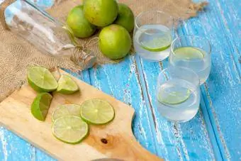 Suco de limão e limão em uma mesa de madeira azul