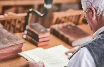 Vanem mees vaatab antiikraamatuid