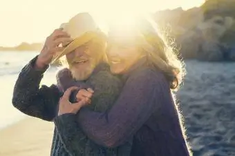 Щастлива възрастна двойка се прегръща в слънчев ден