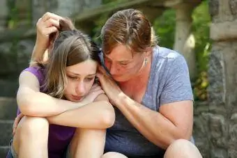 Frau umarmt Teenager-Mädchen