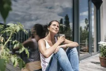 balkonunda güneşin altında oturan kadın