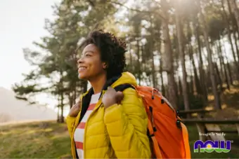 femme souriant lors d'une randonnée dans les bois