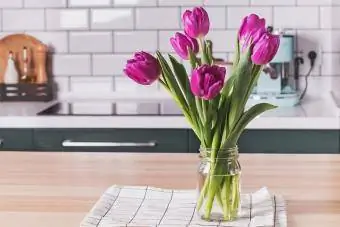 fialové tulipány ve váze na kuchyňské lince