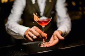Fancy cocktail i hendene på mannlig bartender