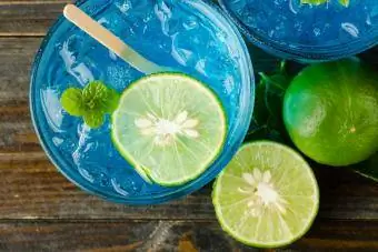 Cocktail ya Bluejito na chokaa kwenye mandharinyuma ya mbao