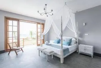 מיטת אפריון עם כילה נגד יתושים בחדר מלון מואר