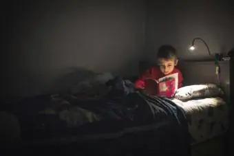 Chlapec čte v posteli