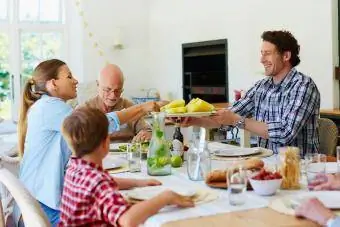 Família fazendo refeição na mesa de jantar