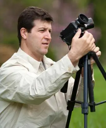 Mees kasutab kaamera statiivi