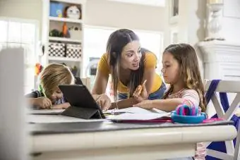 Anne çocuklarına okul ödevlerinde yardım ediyor