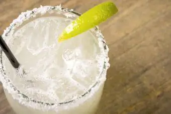 Margarita in bicchiere con una fetta di lime e un bordo ricoperto di sale