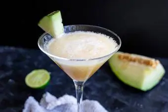 Melonen-Margarita in einem Martini-Glas mit Limette und Melone
