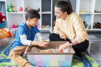 Donna con bambino che gioca con il contenitore sensoriale