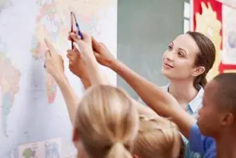 Uma turma animada apontando para um mapa-múndi