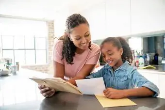 Ibu dan anak perempuan memeriksa surat di rumah