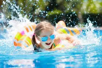 دختری که به سرعت با شناور استخر شنا می کند