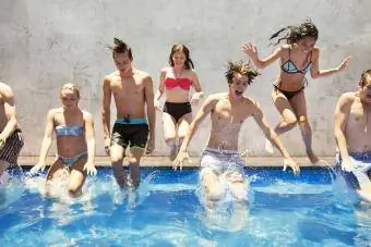 gruppe af teenagere hopper i pool