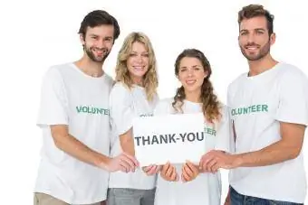 voluntarios sosteniendo tablero de agradecimiento
